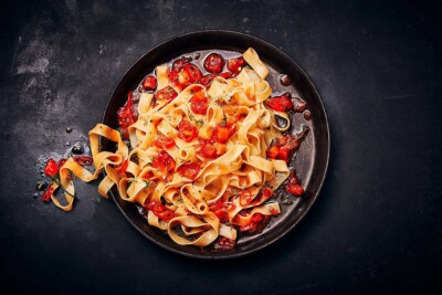 Dark food: Bandnudeln in Tomatensauce auf schwarzem Untergrund Food Fotograf