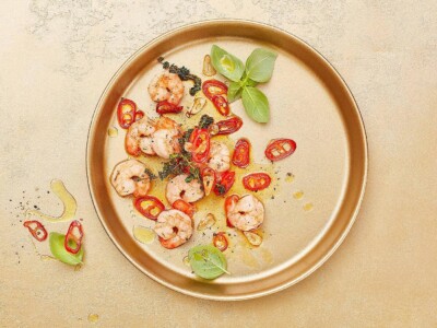 Food Fotografie Schrimps auf goldenem Untergrund für ein Restaurant in Düsseldorf. Foodfotograf: Shrimps & Chilli in Olivenöl auf goldenem Teller.