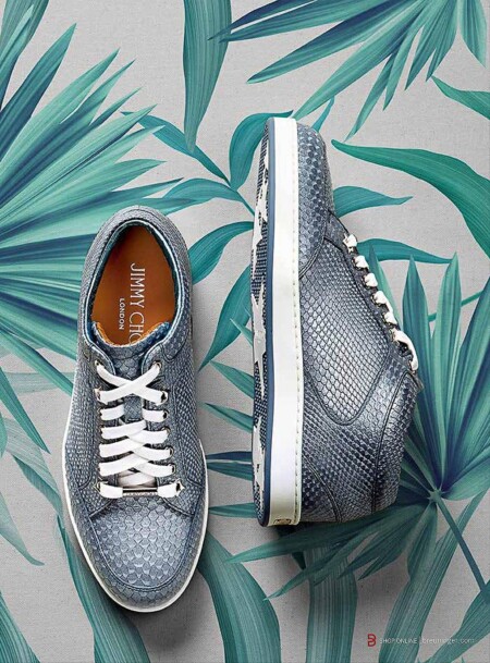 Blaue Jimmy Choo Sneaker auf Blumenuntergrund.