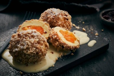 Nahaufnahme Marillenknödel mit Vanillesauce. Nahaufnahme Marillenknödel mit Vanillesauce.